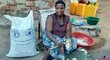 a woman is cooking next to WFP sack